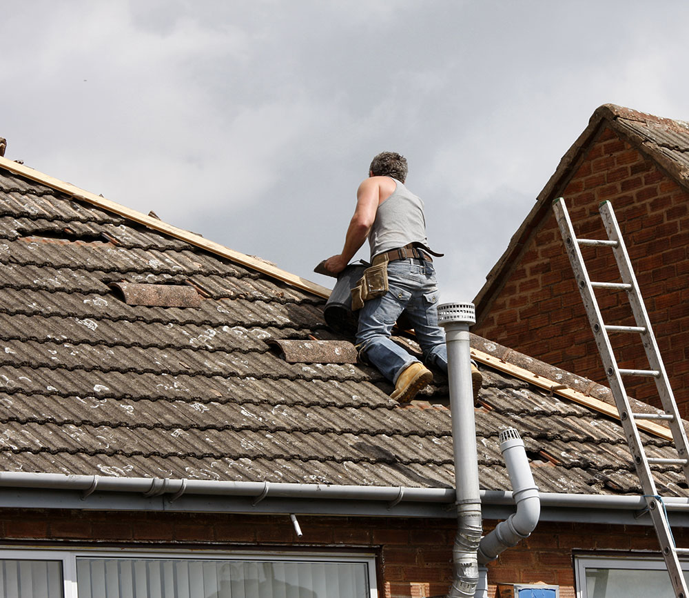Workers from Southampton Roofing performing repairs on a house exterior as part of roof repairs in Eastleigh, with ongoing construction.