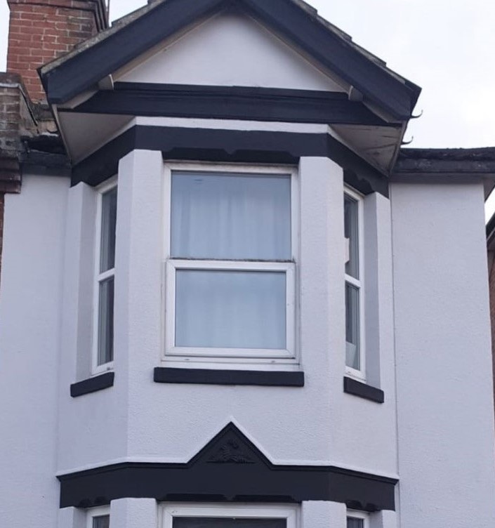 Workers from Southampton Roofing performing repairs on a house exterior as part of roof repairs in Eastleigh, with ongoing construction.