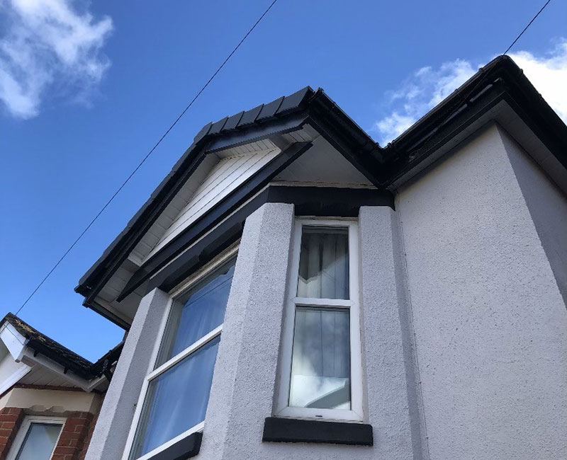 Workers from Southampton Roofing performing repairs on a house exterior as part of roof repairs in Eastleigh, with ongoing construction.