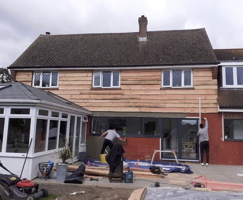Workers from Southampton Roofing performing repairs on a house exterior as part of roof repairs in Eastleigh, with ongoing construction.